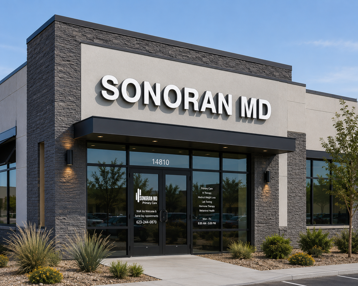A front-facing view of a sleek, modern medical clinic building bathed in the warm glow of golden-hour light, featuring a clean stone and stucco facade with large glass windows and sharp architectural details. The noticeable "SONORAN MD" sign crowns the structure, while desert-friendly landscaping and an inviting interior with soft lighting peek through the glass, highlighting the professional services offered within.